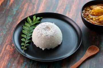 Rice Puttu or pittu steamed rice cake and egg roast curry popular in South Indian states of Kerala, Tamil Nadu, Karnataka,  Sri Lanka.	