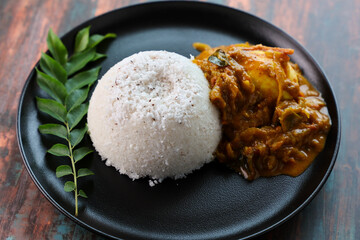 Rice Puttu or pittu steamed rice cake and egg roast curry popular in South Indian states of Kerala, Tamil Nadu, Karnataka,  Sri Lanka.	
