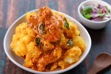 tapioca and spicy hot Kerala fish curry Indian food. Kappa king fish masala curry. Asian cuisine Bengali macher Jhal Goan fish curry in coconut milk Cassava root , Mandioca Sri Lanaka Tamil nadu