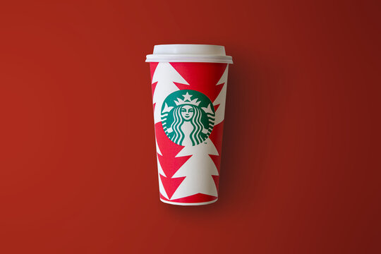 Bangkok, Thailand - November 10, 2022: Starbucks new 2022 designed Christmas holiday tall cup on red background. Starbucks is the world's largest coffee-house company.