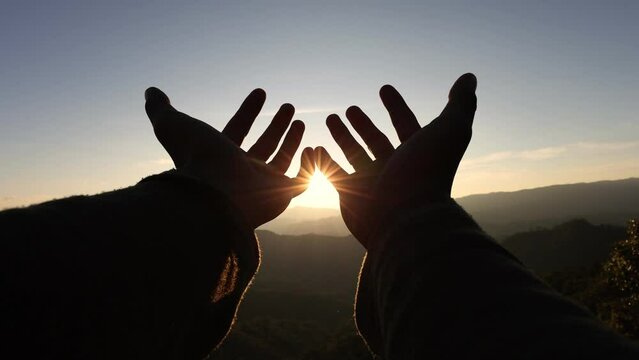 close up silhouette  stretches out her hand in the sun. sunlight dream of happiness  faith in god dream a religion concept. hand in the sun. morning prayer.