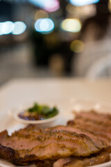 Charcoal-boiled pork neck on white dish. Grilled pork Thai food