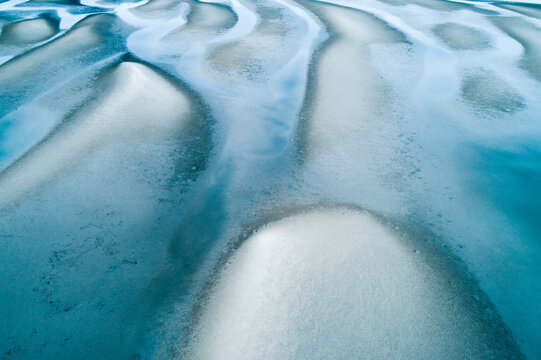 Aerial view of sandbar patterns in shallow blue water.