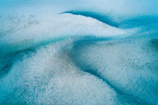Aerial view of sandbar patterns in shallow blue water.