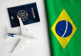 Flag of Brazil with passport and toy airplane. Flight travel concept
