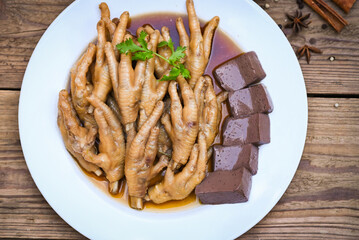 Cooking chicken feet foot stew on white with herbs and spices ingredients with chilli lemon vegetable on wooden background, Asian chinese food menu stew, Thai food, chicken feet soup stewed