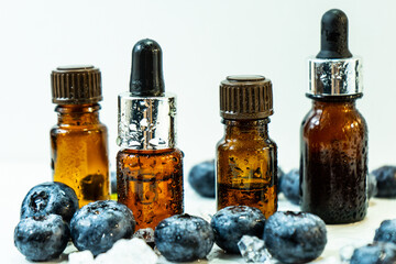 Blueberry essential oil. Organic cosmetics. Cosmetic oil with blueberries in mini bottles and blueberries. Spa treatments for relaxation. Selective focus. 