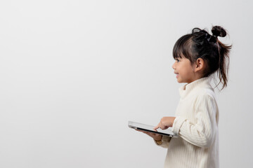 Asian little girl holding and using the digital tablet on white studio background, free copy space