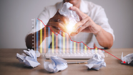 Depressed Businessman Leaning His Head Below a Bad Stock Market Chart
