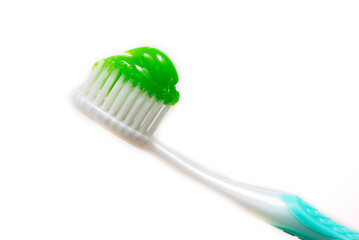A toothbrush in close-up, on which green toothpaste was squeezed out
