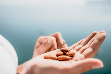 Young milky almond nuts in womans hand. A young caucasian woman