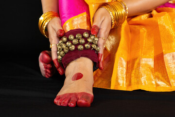 Bharatanatyam Indian classical dancer feet in close up view wearing ghungroo with traditional...