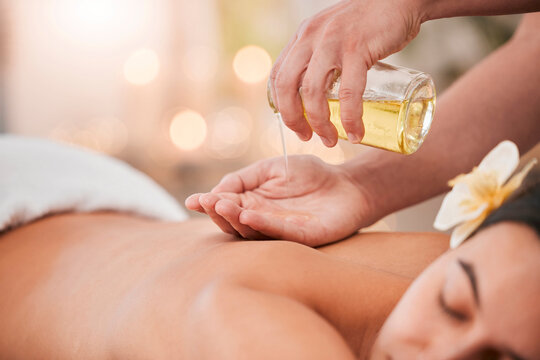 Hand, oil and massage on woman at a spa for wellness, relax and stress relief with back massage and masseuse. Luxury, back and girl hands of therapist with product for body, skin and muscle therapy