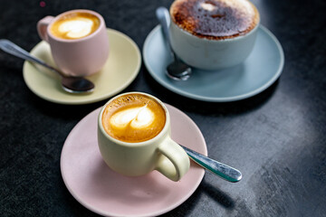 Lattes and Mocha on colorful pastel cups on a table