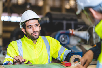 professional technician engineer with safety hard hat working to maintenance construction equipment in industrial factory, inspection man having manufacturing occupation job of production technology