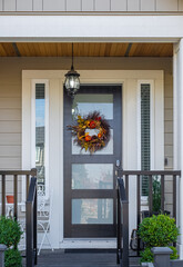 Front door of beautiful house with colorful flower wreath. Decoration on the wooden door.