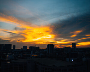 Plakat Horizon at sunset with golden blue sky with some clouds. City silhouette.