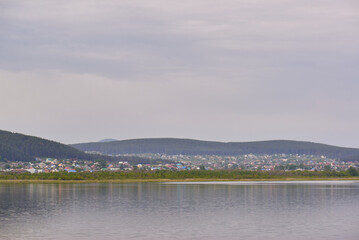 view of a beautiful city by the lake surrounded by low mountains