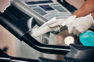 Hands, spray bottle and covid cleaning in gym for healthcare compliance, medical safety and global...