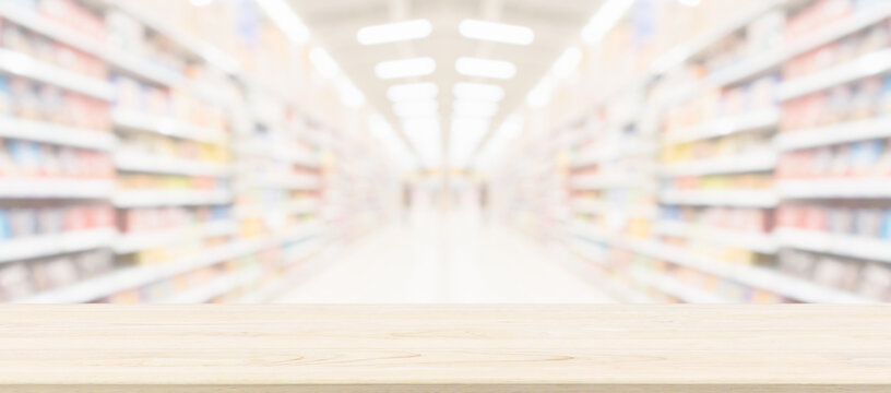 Wood table top with supermarket grocery store blurred background with bokeh light for product display