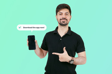 Happy Guy having smart phone with black screen in hand, pointing with forefinger to product. Guy...