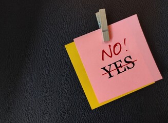 Pink note on black background with text written YES, was changed to NO!, concept of people pleaser or people who always say yes learning to say no without feeling guilty