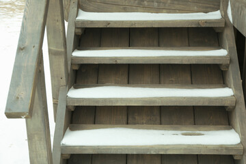 Wooden steps with snow of cozy wooden house outdoor