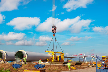 Construction work by crane. one blade laying on the ground. Building and assembling a windturbine. Green energy, ecology, CO2-footprint  reduction concept. W&ouml;rrstadt 