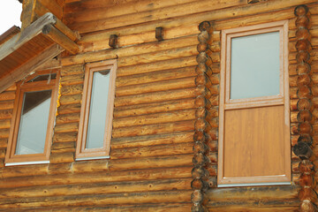 Obraz na płótnie Canvas Windows of cozy wooden house outdoor in winter season
