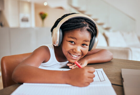 Education, elearning and headphones of african child listening to audio translation, language learning and writing notes in book. Black girl kid at home with e learning, online education and portrait
