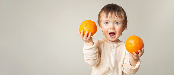 a baby with a food allergy holds oranges in his hands, the child has red cheeks, irritation