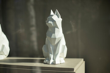 Figure of cat. Sculpture made of white plastic. Interior details.