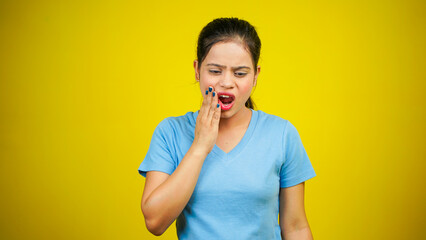 Young girl touching mouth with hand with painful expression because of toothache or dental illness on teeth, dentist concept, isolated over yellow background