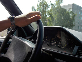 A man's hand on the steering wheel of a car. Driving. Close-up
