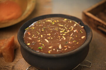 ragi malt, finger millet porridge served in a traditional mud pot served  closeup with selective focus and blur