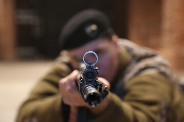 Military man with a weapon aiming through the scope