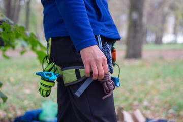 A climber in training in a safety harness, he has a lot of carabiners and other equipment