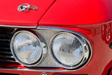 Detail of an headlight of a vintage italian red sport car