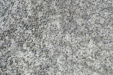 Gray washed out earthen floor texture background. Pebble-filled road surface.