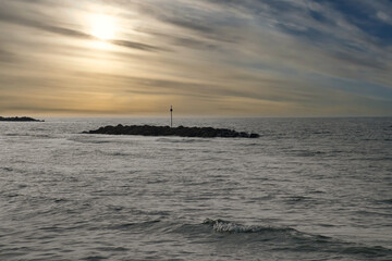 Stone groynes, breakwaters in the water off the coast in Denmark. In the evening