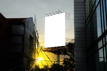 Portrait billboard white blank for outdoor advertising at sunset city background.