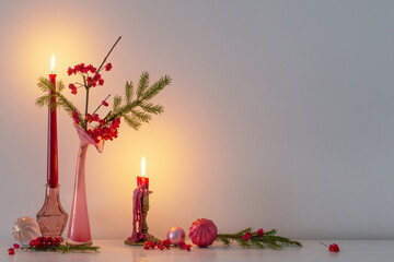 pink christmas decor with burning candles in white interior
