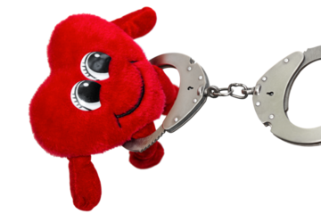 heart in handcuffs, a fun soft toy in handcuffs, on an isolated background