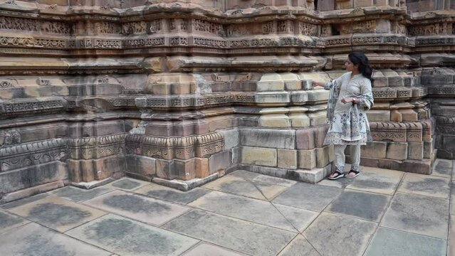 Beautiful Indian Woman Touching And Admiring The Intricate Stone Wall Carvings Outside The Temple Of Khajuraho In Madhya Pradesh, India. - Slow Motion