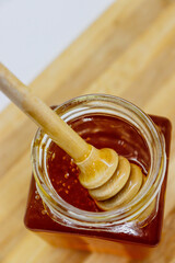 Sweet honey in a jar and on a stick