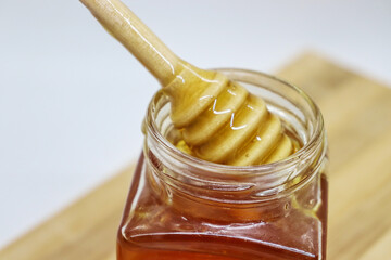 Sweet honey in a jar and on a stick