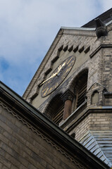 Blick von unten nach oben auf die Uhr einer Kirche, vertikal 