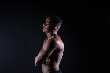 Naklejka premium Portrait of an athletic african american man topless, black background