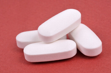 Comprim&eacute;s de parac&eacute;tamol en gros plan sur fond rouge