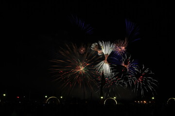 Multicolored fireworks in the dark sky, city day celebration.